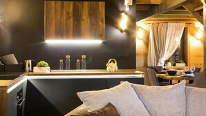 Une cuisine moderne avec un plafond en bois, un îlot central intégré et un coin repas comprenant une table et des chaises.