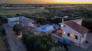 A modern villa with a swimming pool, outdoor seating, and a view of the countryside at sunset. - Modern Countryside Villa Near the Sea, Private Swimming Pool, Lovely Guesthouse (Polaca)
