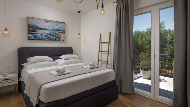 A modern bedroom with a large bed, a painting, and a balcony with a view. - Modern Countryside Villa Near the Sea, Private Swimming Pool, Lovely Guesthouse (Polaca)