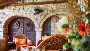 Un intérieur rustique avec des murs en pierre, des portes en bois et des meubles en osier.