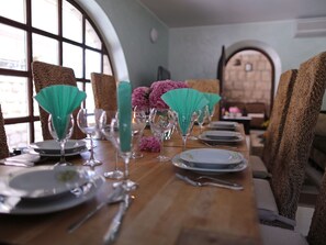 A dining table set with plates, glasses, and teal napkins.