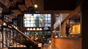 A modern interior with a staircase, seating area, and a counter. - BED STATION HOSTEL KHAOSAN (Bangkok)