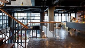 A modern interior with a staircase, a pool table, and large windows. - BED STATION HOSTEL KHAOSAN (Bangkok)