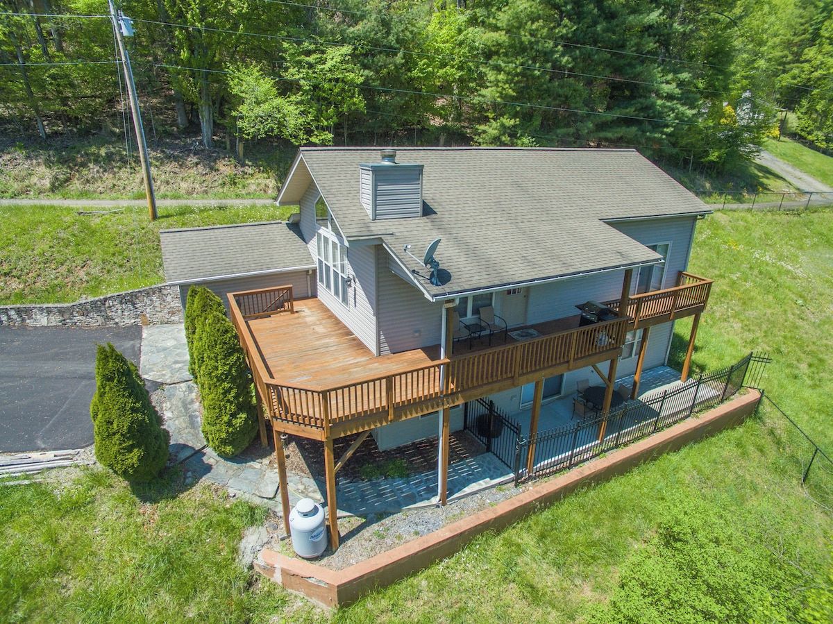 A two-story house with a covered porch and a satellite dish.