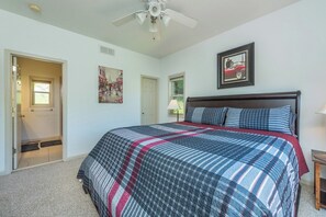 A bedroom with a bed, a ceiling fan, a door, and a window. - Blue Ridge Daze | Fireplace~Pet Friendly~Near Town (Burnsville)