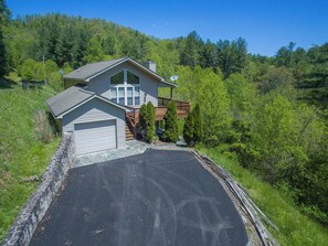 A two-story house with a garage, a deck, and a driveway. - Blue Ridge Daze | Fireplace~Pet Friendly~Near Town (Burnsville)