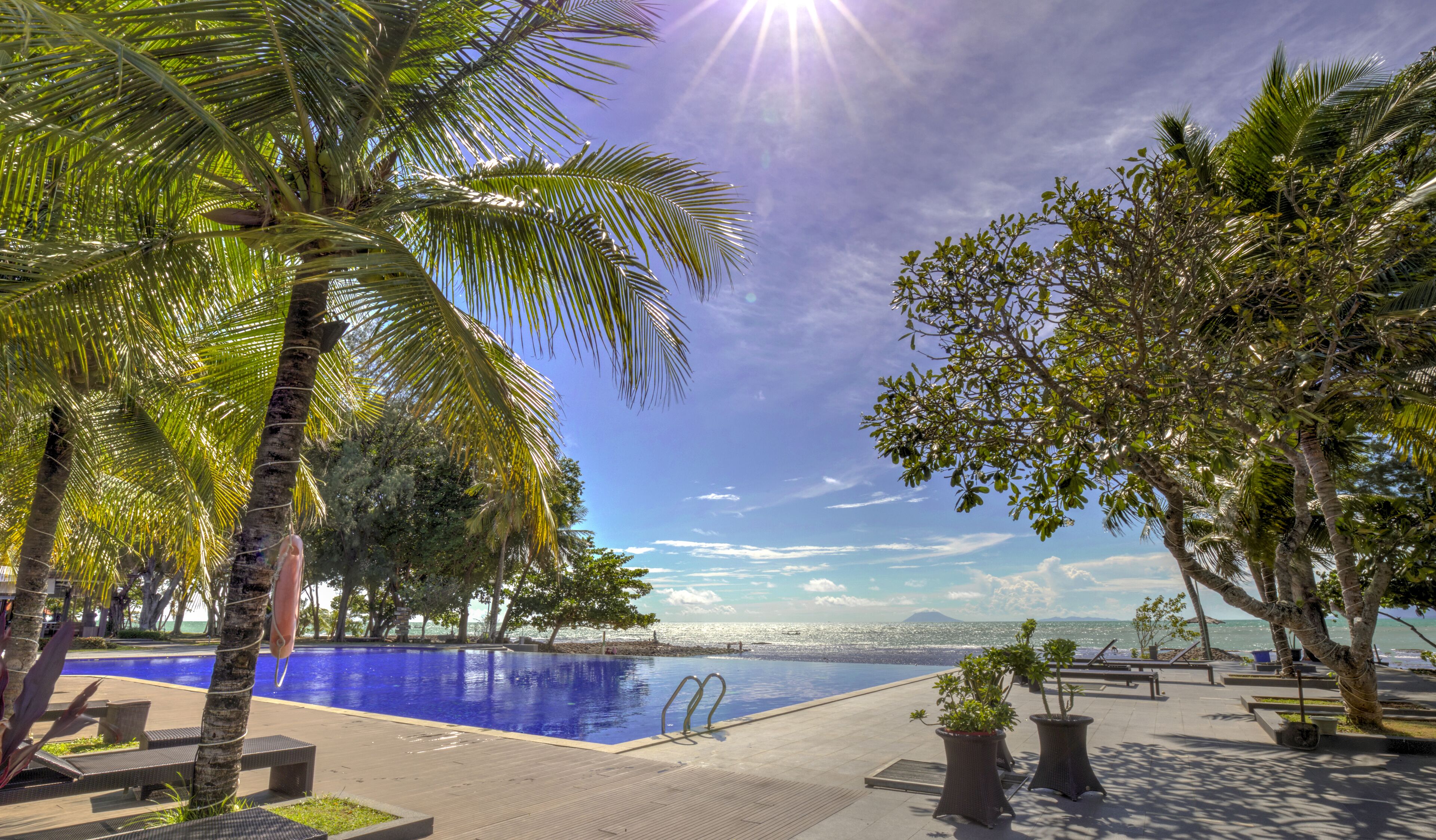 Una piscina al aire libre, sillones reclinables de piscina