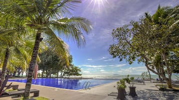 Una piscina al aire libre, sillones reclinables de piscina