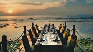 A table set for dining with a view of the ocean and sunset. - Mambruk Hotel & Convention (Anyer)