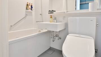 A modern bathroom with a bathtub, a sink, and a toilet.