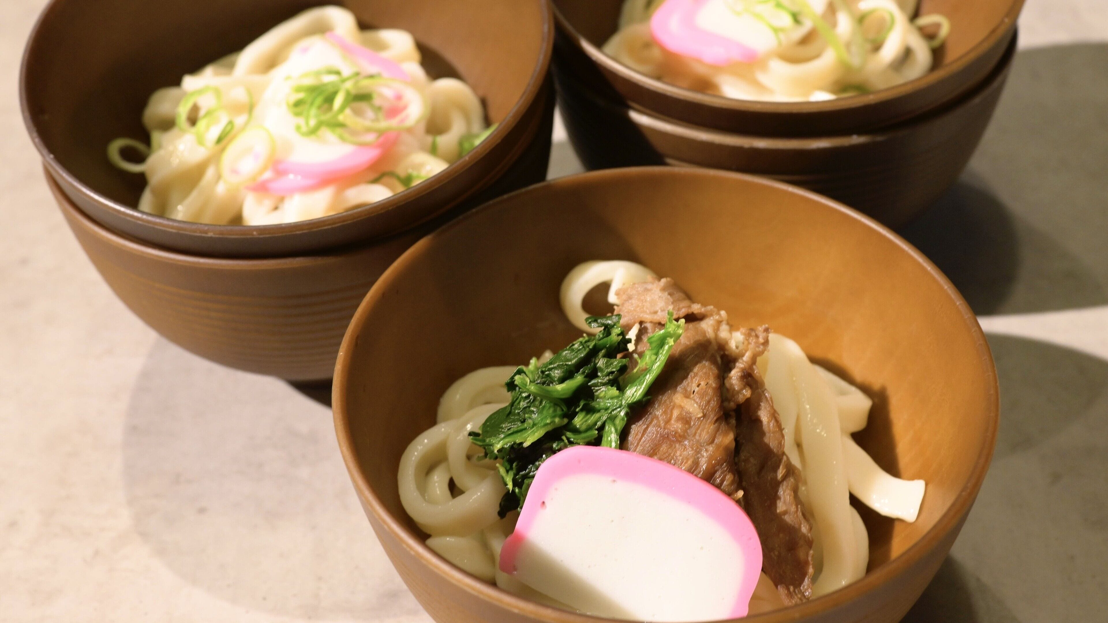 Three bowls of ramen with different toppings.