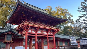 A traditional Japanese building with a prominent red structure and a curved roof.