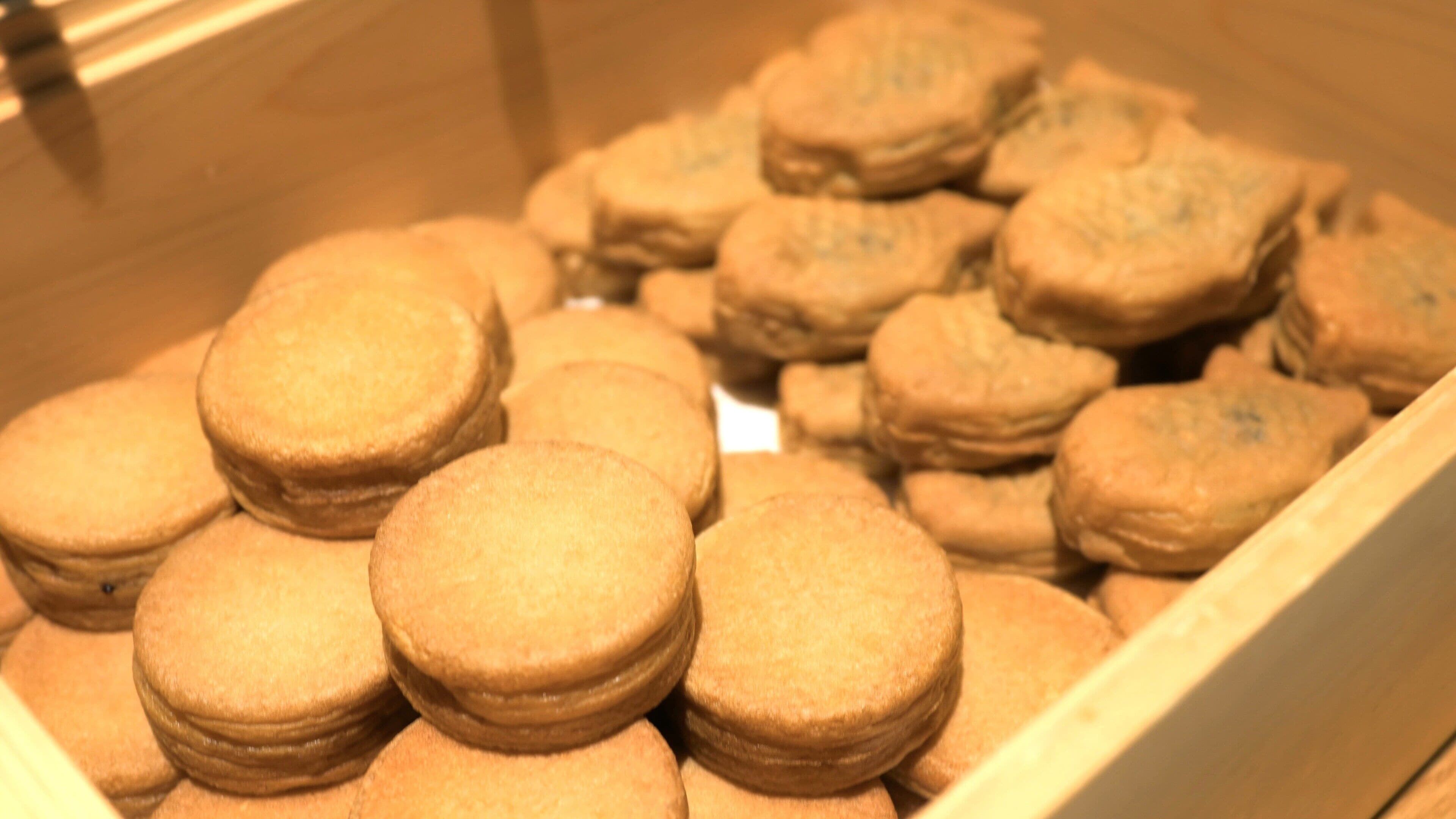 A display case filled with round, golden-brown cookies.