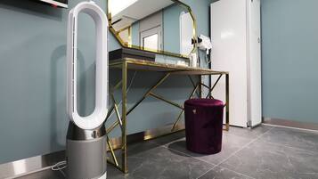 A bathroom with a toilet, bidet, sink, mirror, and a white cabinet.
