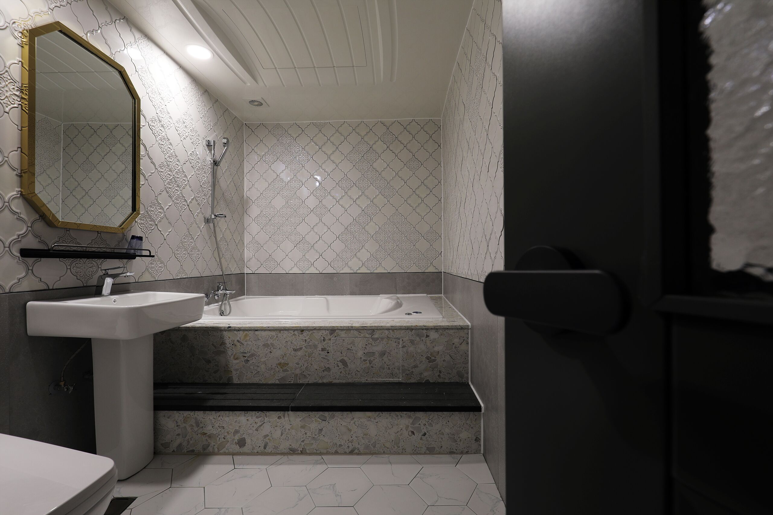 Un baño con lavamanos, espejo, ducha y bañera.
