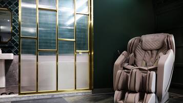 A massage chair in a room with a tiled floor and a large window with a view.