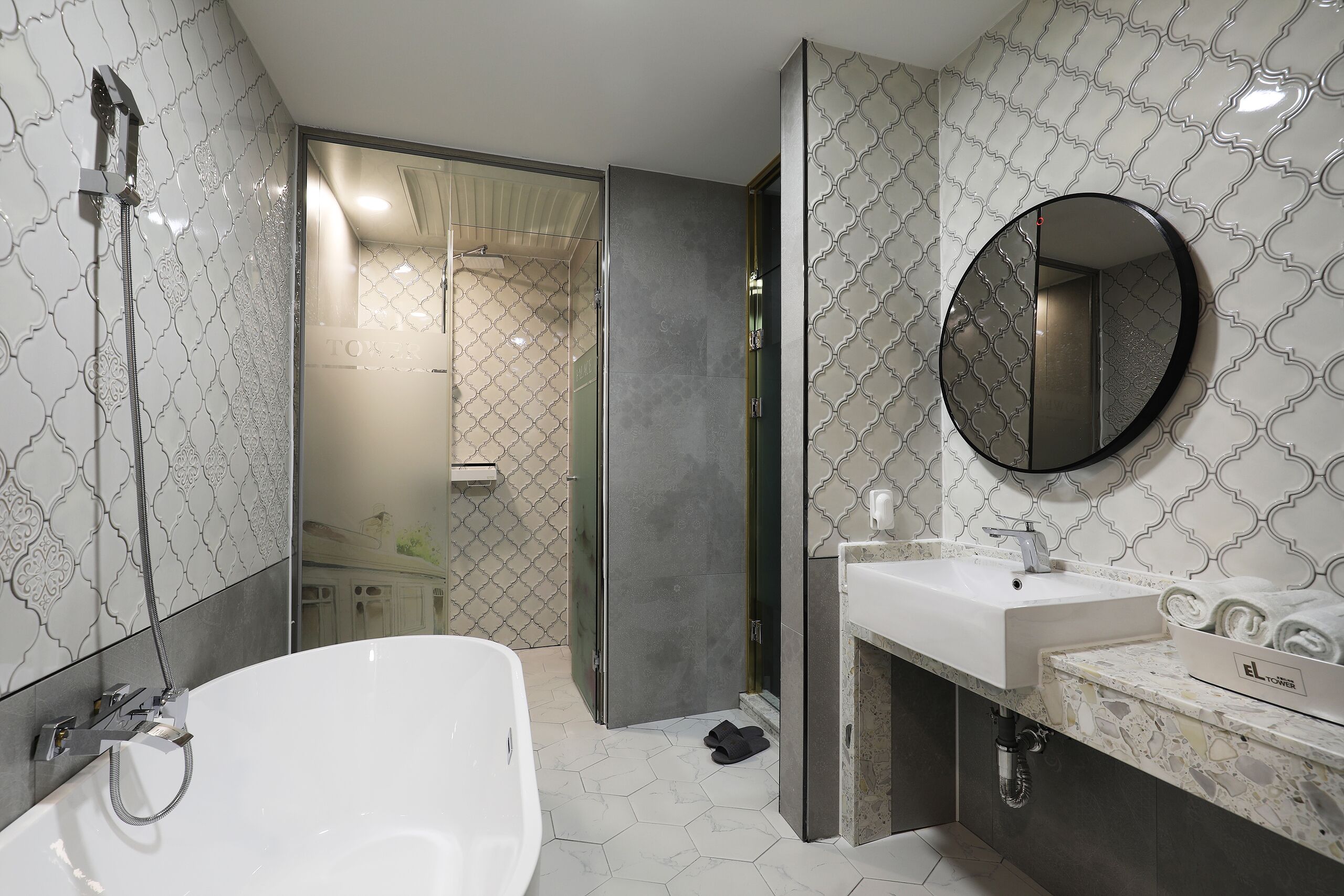 A modern bathroom with a freestanding bathtub, a vanity with a mirror, and a shower area.