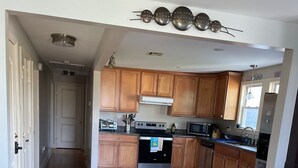Una cucina moderna con mobili in legno, elettrodomestici in acciaio inossidabile e un pavimento in legno a spina di pesce.