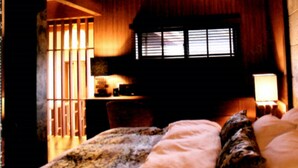A wooden cabin interior with a bed, a desk, and a window. - Indigo Geohouse DS1 (Iwami)