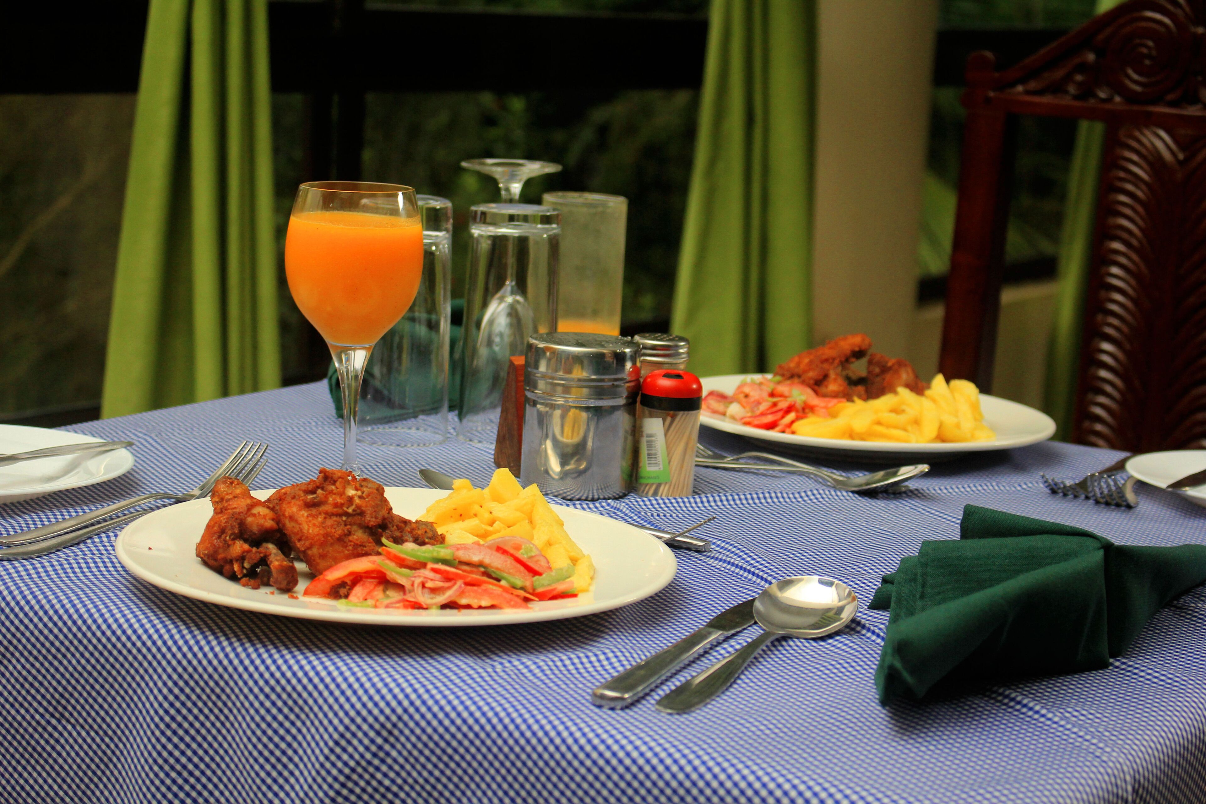 A table set for a meal with plates of food, cutlery, and condiments.