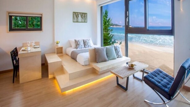 Una sala de estar moderna con un sofá, una mesa de centro y vistas a la playa.