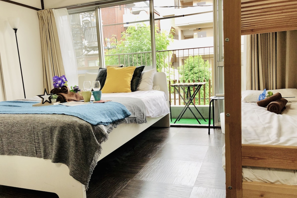 Una habitación de hotel moderna con una cama grande, una mesita y un balcón con vistas a la ciudad.