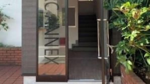 A modern building entrance with a glass door and a staircase leading inside. - Rc Annex 2 (Tokyo)