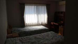 Een kamer met twee bedden, een bureau en een stoel.