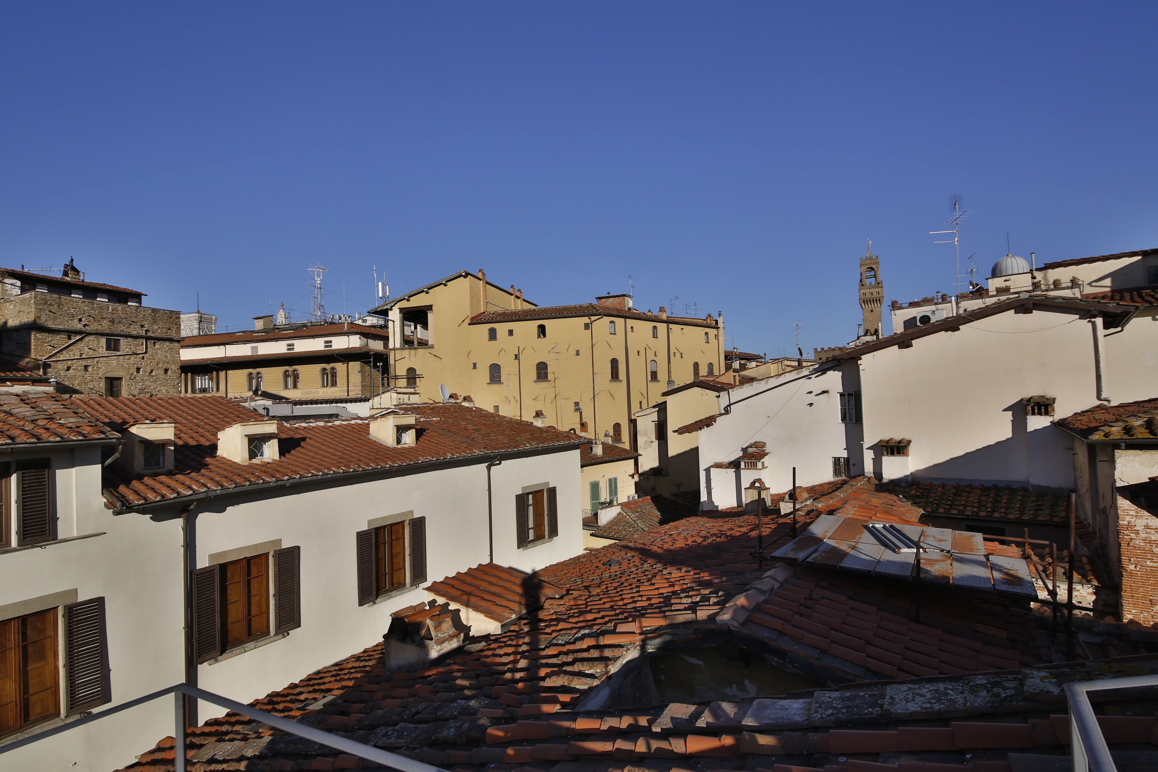 A densely packed urban area with traditional architecture, featuring terracotta roofs and a mix of building heights.