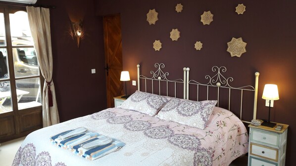 Relax in a classic bedroom with a large bed, wooden door, and window with a view.