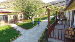 Un patio con un camino de piedra, mobiliario exterior y una pérgola.