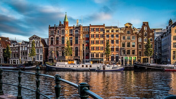 A canal with historic buildings and a boat. - Leonardo Eden Hotel Amsterdam City Center (Amsterdam)
