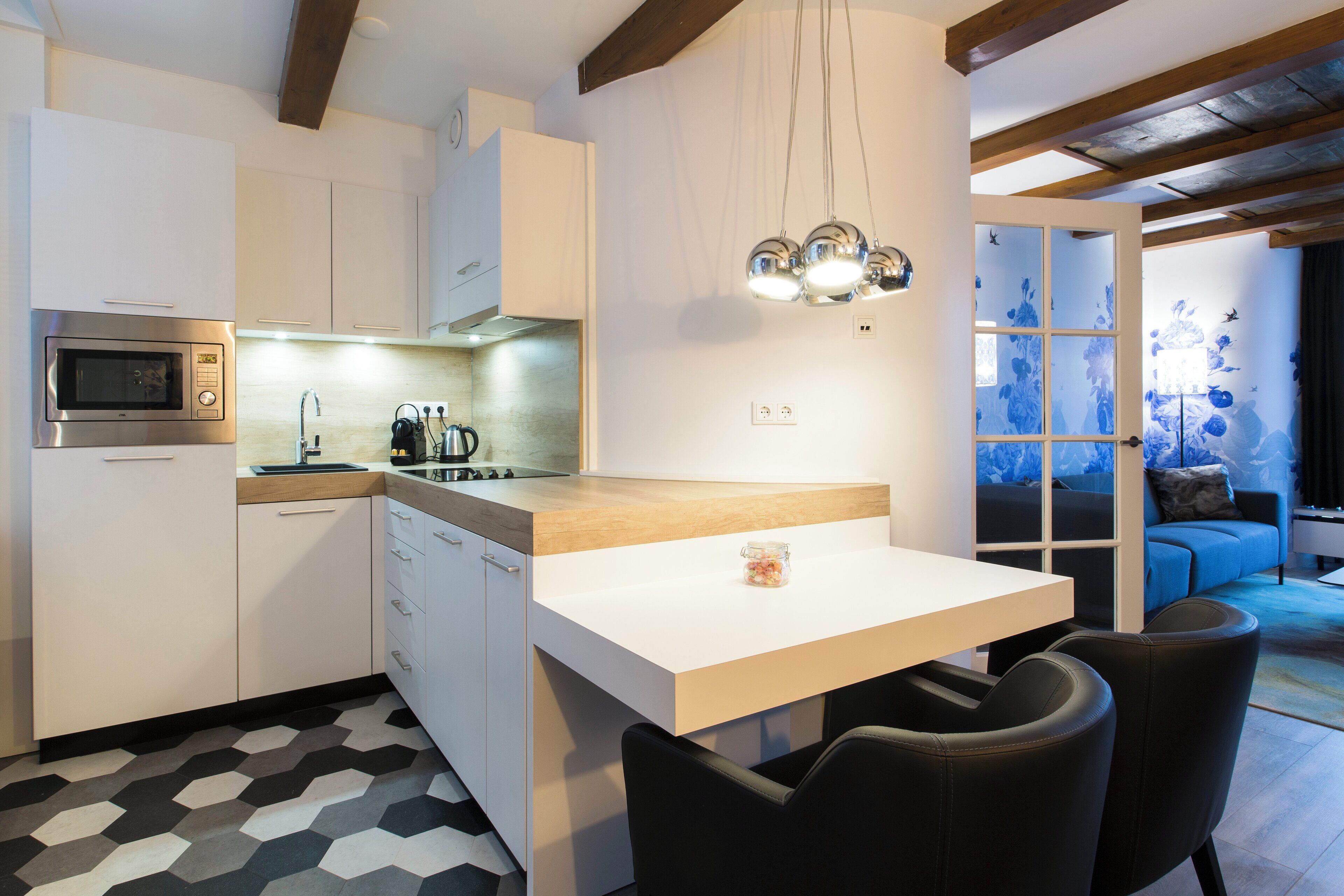 Une cuisine moderne équipée d’un four à micro-ondes, d’un évier et d’un plan de travail en bois. Un coin repas avec une table et des chaises est également disponible.