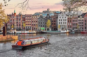 A canal with historic buildings and a boat. - Leonardo Eden Hotel Amsterdam City Center (Amsterdam)