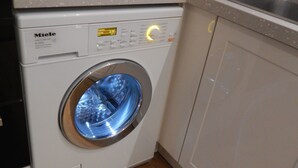 A front-loading Miele washing machine in a kitchen with a countertop and a sink. - Cherry Palace 3 BD Parking Spaces groups (Cambridge)