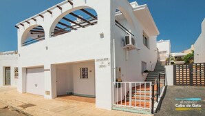 Un edificio blanco con dos puertas de garaje, una escalera y un letrero que dice 'Lillemor 1 Roga'.