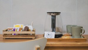 Una cassa di legno con una macchina da caffè, un vassoio e una tazza su un tavolo.