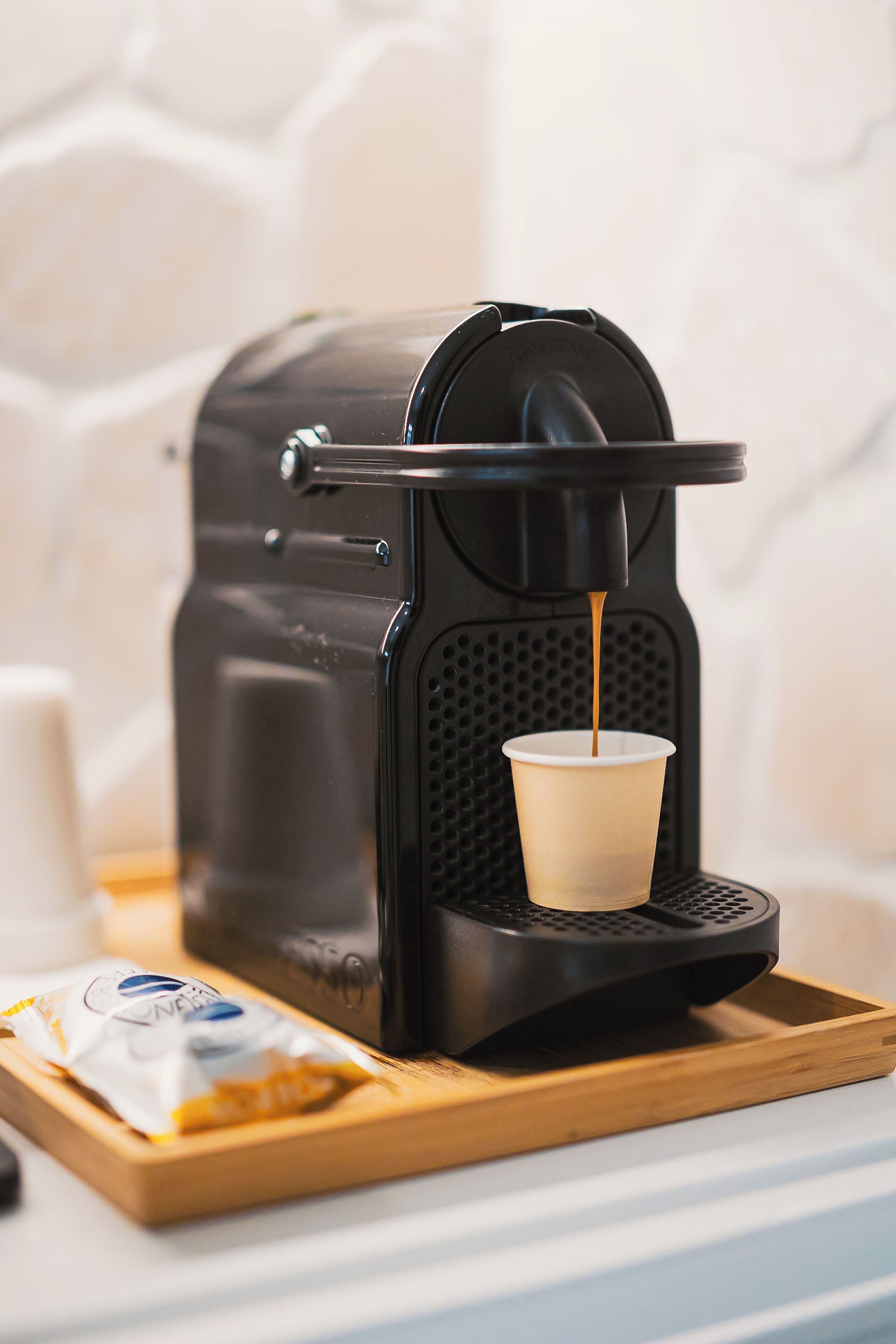 Máquina de café servindo café numa bandeja.