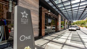 Una entrada de edificio moderno con una cubierta de vidrio y un letrero que dice "STAR RESIDENCES ONE".