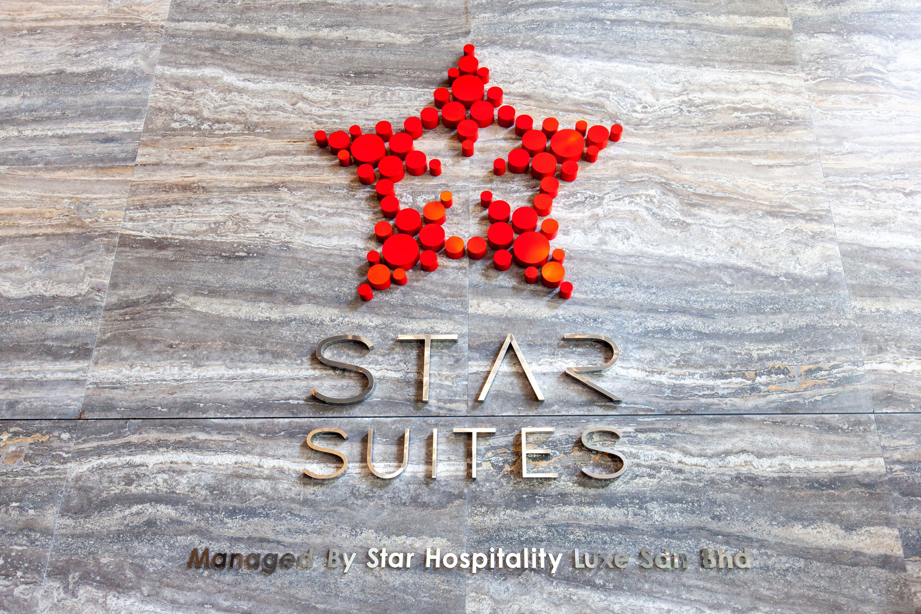 Et logo med en rød stjerne bestående af prikker og teksten 'STAR SUITES' nedenunder.