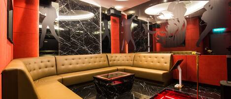 A modern lounge with a curved sofa, a marble coffee table, and a large mirror with a lion silhouette.