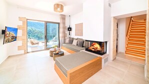 Una sala de estar moderna con chimenea, un sofá y una zona de comedor.