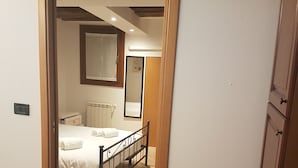 A bedroom with a bed, a nightstand, a mirror, and a radiator. - Corte dei Bari (Venice)