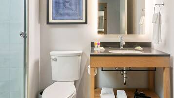 A modern bathroom with a toilet, sink, and shower.