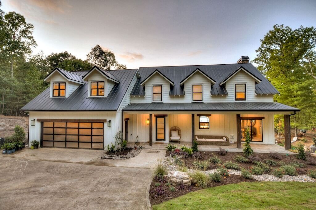A two-story house with a garage, a covered porch, and a landscaped front yard.