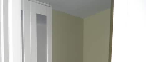 A room with a wardrobe, a bed with a patterned bedspread, and a light-colored floor.