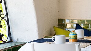 Ein Tisch mit einer weißen Tasse, einem Keramikbehälter und einer weißen Kaffeetasse.