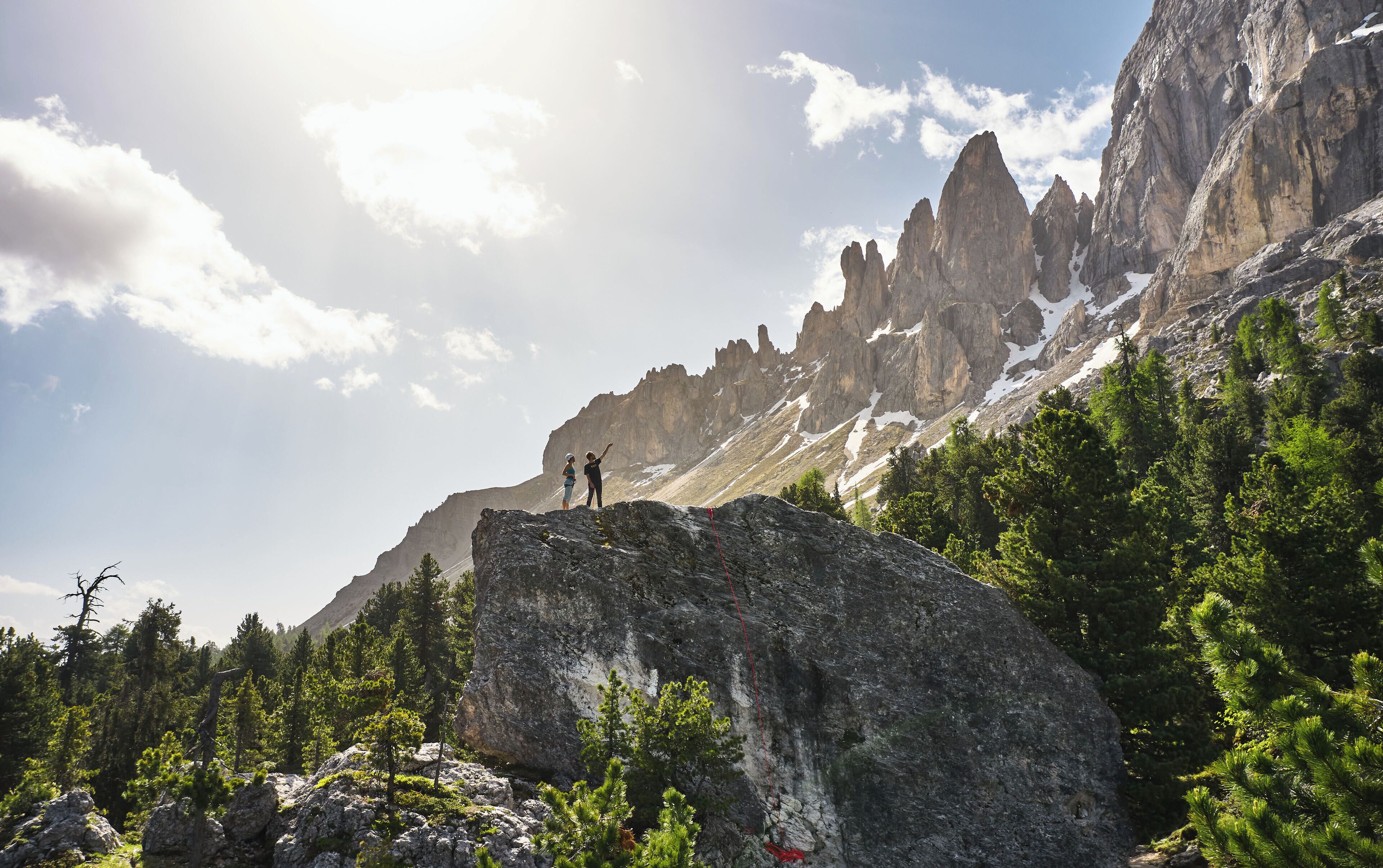 Paisaje montañoso con una persona de pie sobre una roca.
