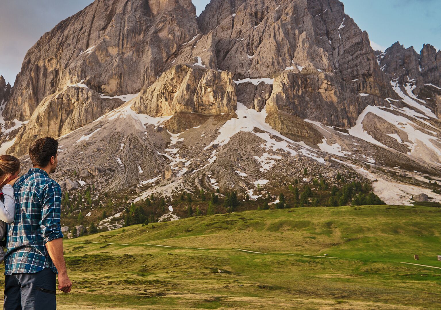 A mountainous landscape with rocky peaks and patches of snow.