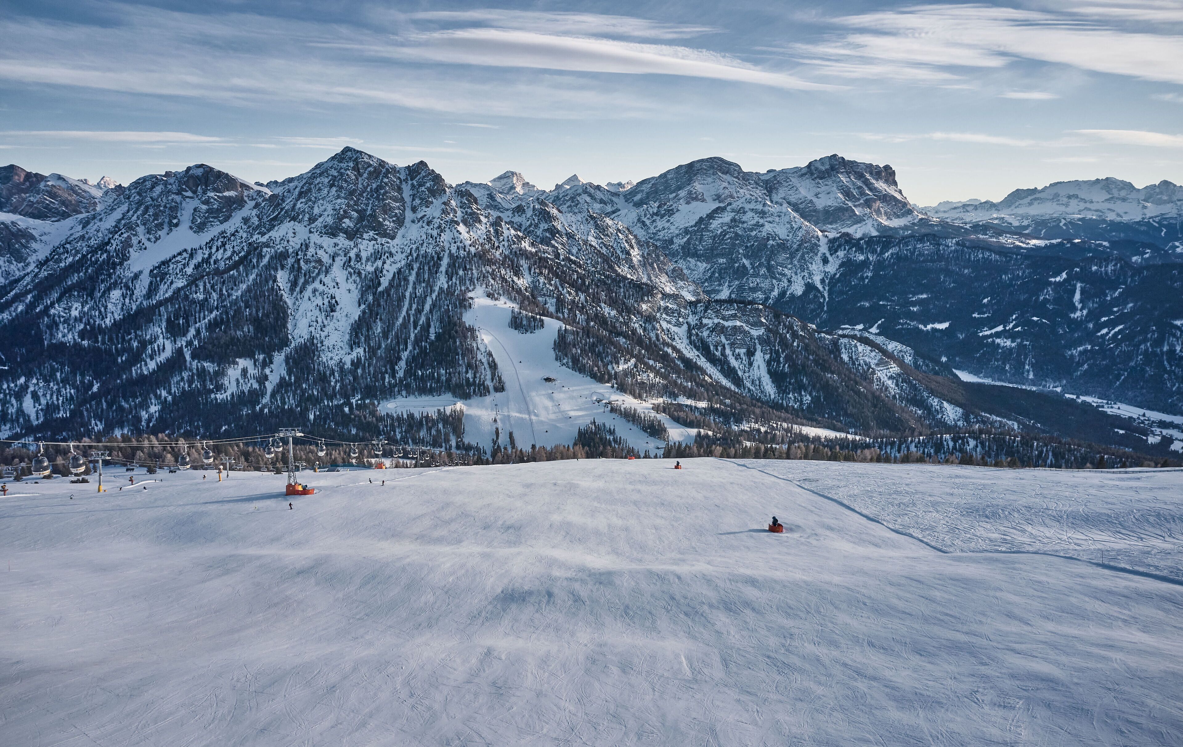 Un paysage montagneux enneigé avec des pistes de ski et un télésiège.